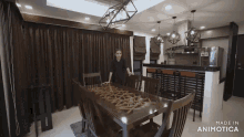 a woman stands in a dining room with the words made in animotica at the bottom