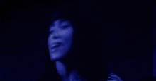 a blurry picture of a person 's face in a dark blue room .