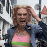 a woman is making a funny face in front of a building that says live friends square