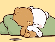 two teddy bears are hugging each other while laying on a blanket .