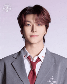 a young man wearing a suit and tie with boys on the planet written on the sleeve