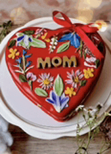 a red heart shaped can with the word mom on it