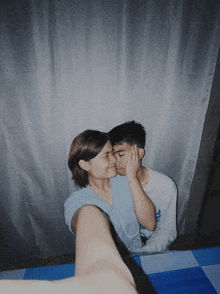 a man and a woman are kissing and the man is wearing a nike shirt