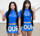 two women wearing blue tops and skirts that say " our four "