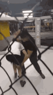 a man is holding another man in a boxing ring with a sign that says verciseless