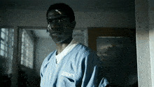 a man with a bandage on his forehead is wearing a blue la county prison uniform