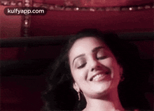 a close up of a woman smiling with her eyes closed .