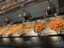 a buffet line with a variety of food including chicken and french fries