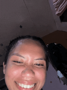 a close up of a woman 's face with her eyes closed and smiling
