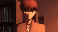 a man with red hair is standing in front of a bookcase