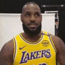 a man with a beard is wearing a lakers jersey .