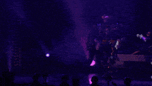 a man in a gray jacket is standing next to a purple costume