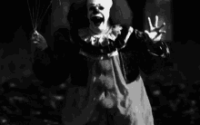 a black and white photo of a scary clown holding balloons in his hand .