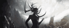 a silhouette of a woman with horns on her head standing in front of a mountain range .