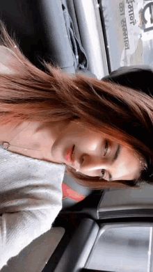 a woman is sitting in the back seat of a car with a sign in the background that says ' a ' on it
