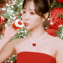 a woman in a red dress is eating a cupcake with a heart on it