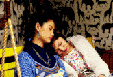 two women are sleeping on a swing in front of a wallpaper with animals on it