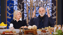 a man and a woman sitting at a table with nbc written on the bottom right