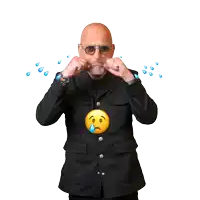 a man in a black jacket is crying with tears falling on his face