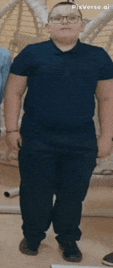 a man wearing a blue shirt and black pants is standing in front of a hammock .