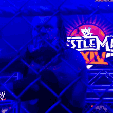 a wrestler behind a chain link fence with a sign that says man