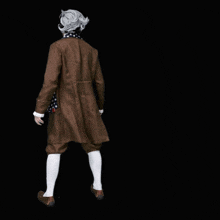 a man in a suit and a scarf is standing in front of the word you
