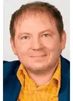 a man wearing a yellow shirt and a blue jacket is smiling