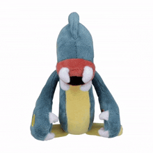 a blue and yellow stuffed animal with a red eye and yellow spots