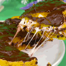 a close up of a piece of chocolate cake with cheese pulling out of it