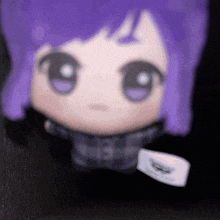 a stuffed doll with purple hair has a tag on it that says ' speedo '