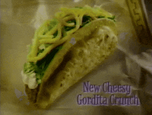a close up of a taco with the words new cheesy gordita crunch below it