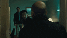 a man in a black jacket is standing in a room