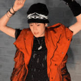 a man wearing an orange vest and a black hat