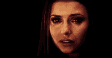 a close up of a woman 's face with a tear coming out of her eye .