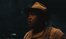a man wearing a hat and suspenders looks to his left