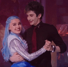 a man and a woman are dancing in a dark room .