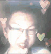 a blurry picture of a man with hearts flying around his face