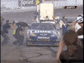a lowe 's impala car is being pushed by a group of people