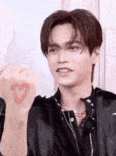 a young man with a heart painted on his wrist .