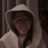 a woman wearing a hooded jacket and a hat that says 16124