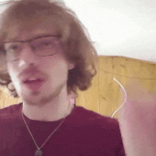 a man with glasses and a beard is wearing a red shirt