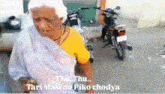 an elderly woman is standing in front of a motorcycle with the words thu thu tari masi no piko chodya on the bottom