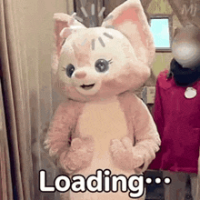 a stuffed animal in a cat costume is standing next to a woman in a mask .