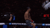 a fighter is being helped by a referee in a boxing ring sponsored by bud light