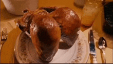 a roasted turkey is sitting on a plate on a table .