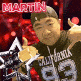 a man wearing a california shirt is holding a microphone