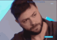 a close up of a man 's face with greek tv news written on the bottom