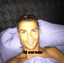 a shirtless man laying in bed with the words hi carson written on his chest
