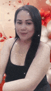 a woman in a black tank top is smiling in front of a floral background