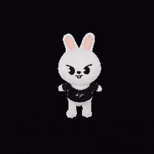 a stuffed bunny is standing on a black background and wearing a black shirt .